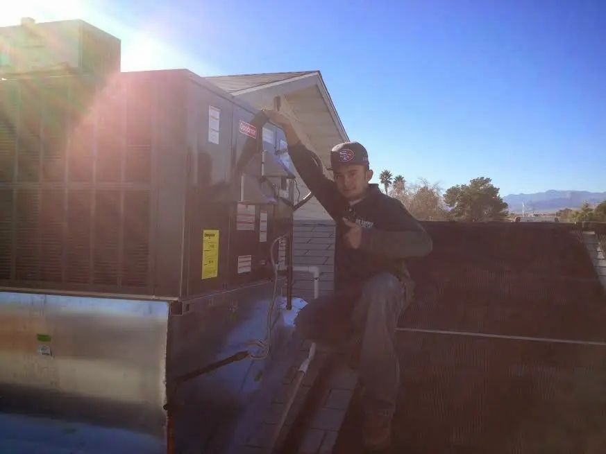 HVAC technician performing Boiler Repair on a rooftop unit in Ammon